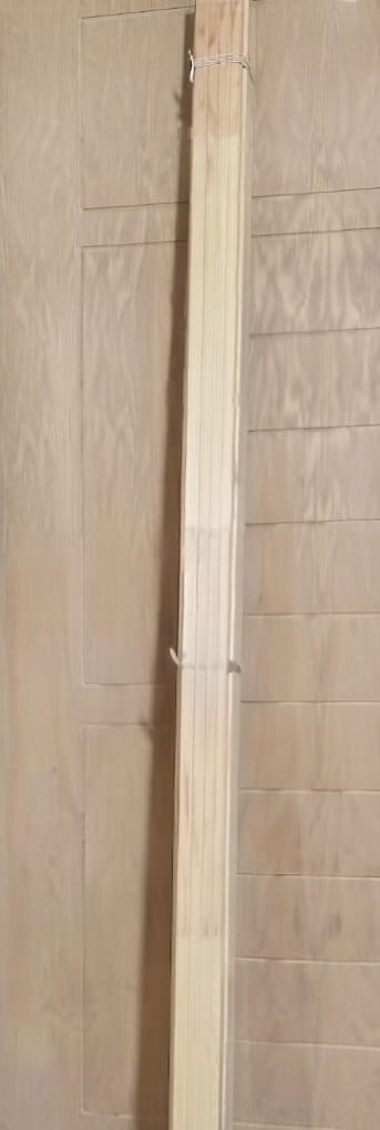Bundle of plain pine wood beading strips against a door